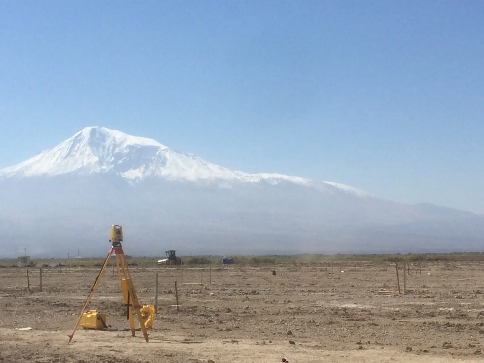 Surveyor's instrument setting out the greenhouse site, with snow-capped Mount Ararat behind